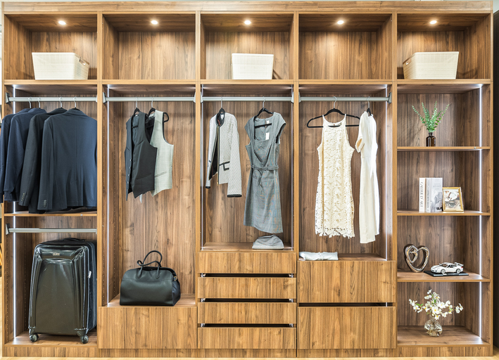 Walnut closet display with drawers, shelves, hanging sections, and LED lights
