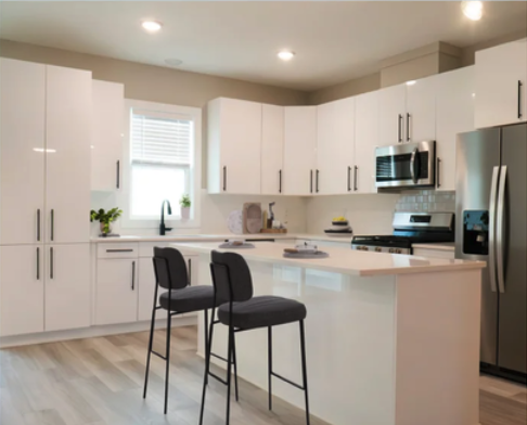 Glossy white frameless kitchen with black appliances